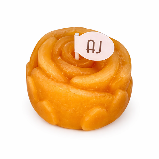 Pure beeswax rose candle with honey and chocolate fudge scent styled on a stone tray with linen and warm decor
